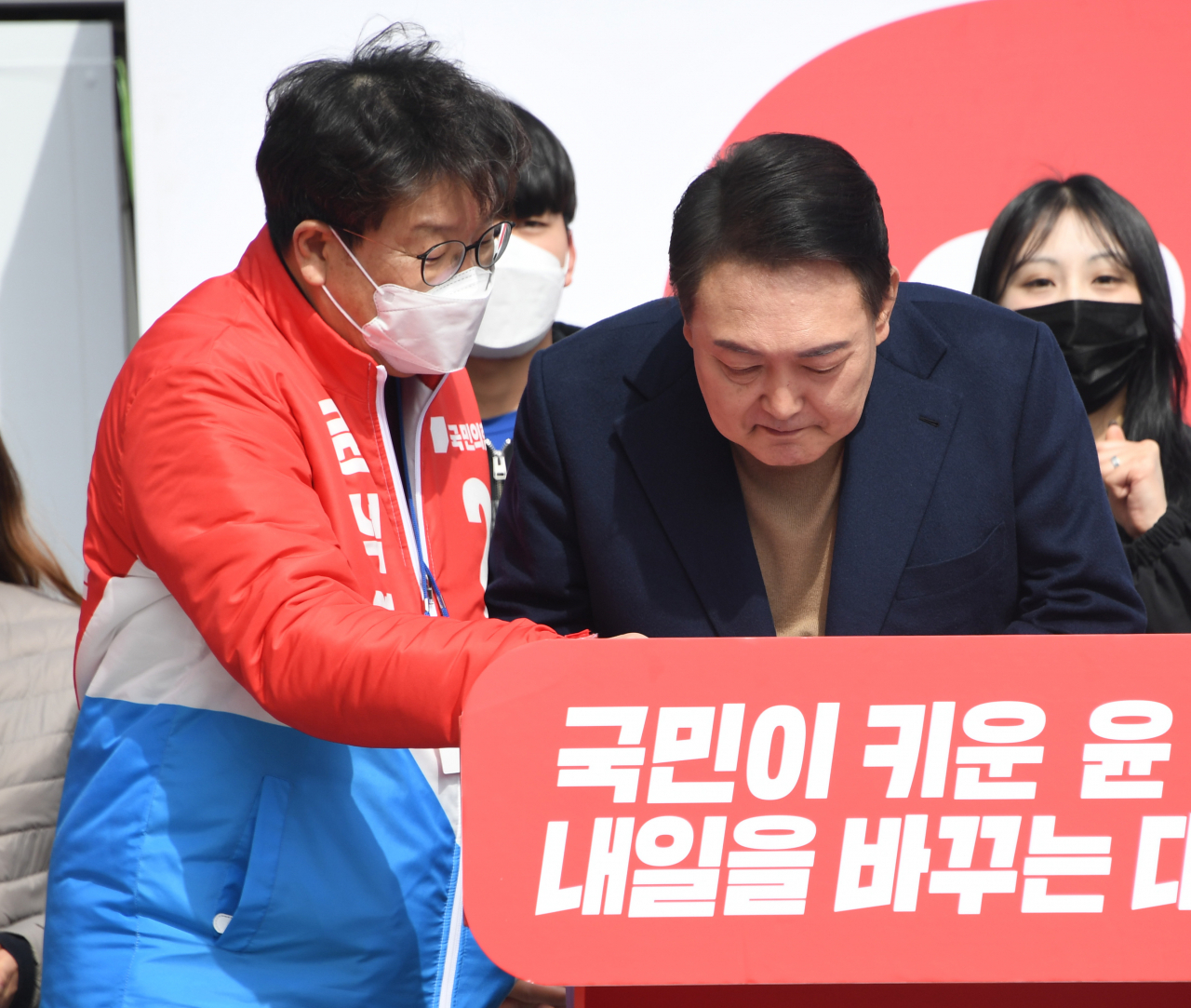 국민의힘 윤석열 대선 후보가 28일 오전 강원 동해시청 앞에서 열린 유세에서 권성동 의원과 대화하고 있다. [연합]