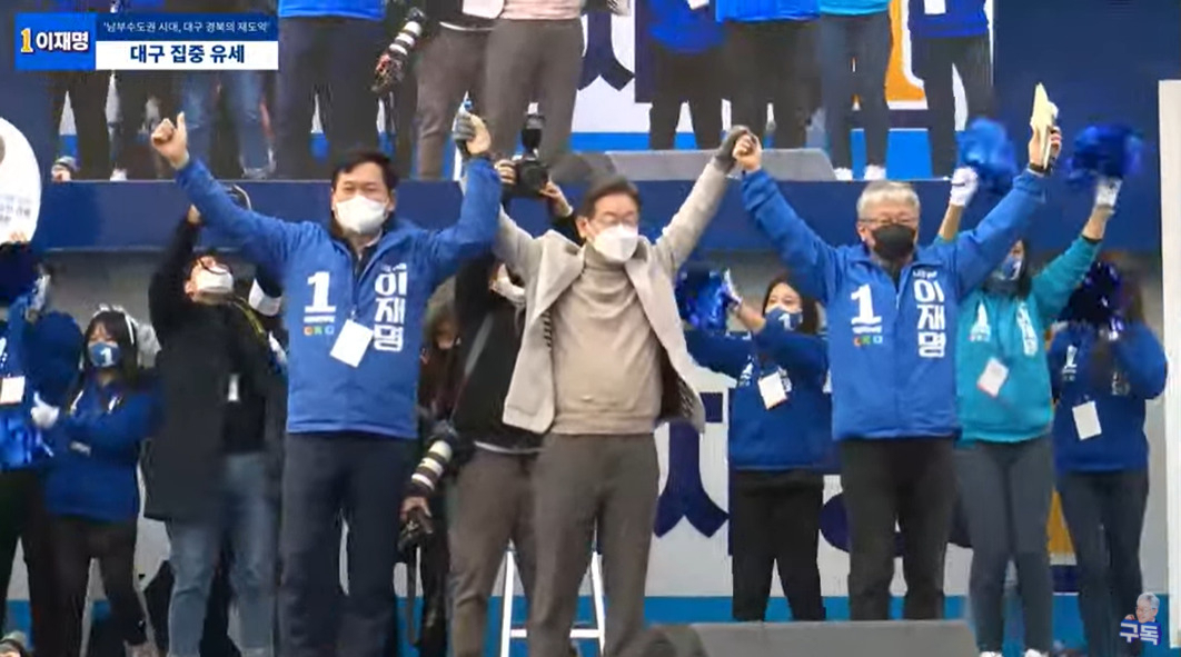이재명 더불어민주당 대선 후보가 28일 오후 경북 동대구역 앞에서 송영길 당대표와 조응천 민주당 의원과 함께 손을 들어 보이고 있다. [이재명TV 캡처]