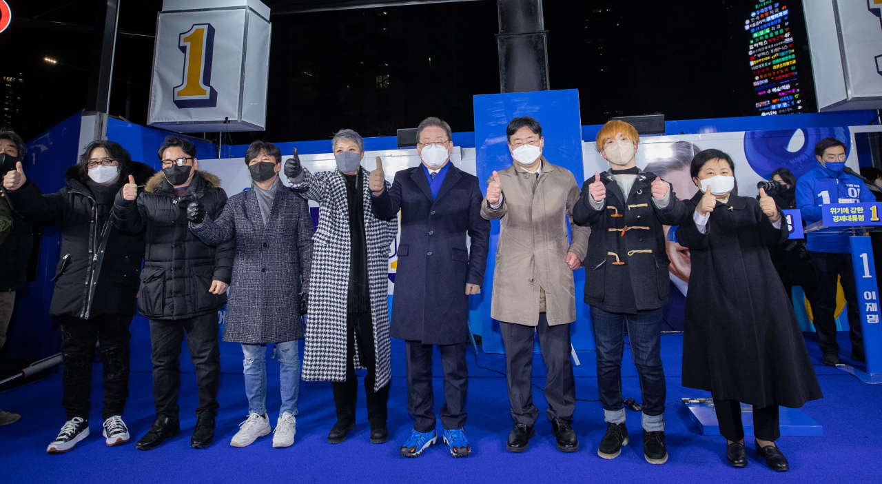 이재명 더불어민주당 대선후보가 지난달 16일 오후 서울 송파구 잠실 새내역에서 지지 발언자들과 함께 엄지를 들어 보이고 있다. 왼쪽부터 기타리스트 신대철, 작곡가 윤일상, 가수 이정석, 가수 이은미, 이 후보, 하준경 한양대 교수, 신홍윤 함께하는장애인위원회 청년본부장, 정현백 전 여성부 장관. [국회사진기자단]