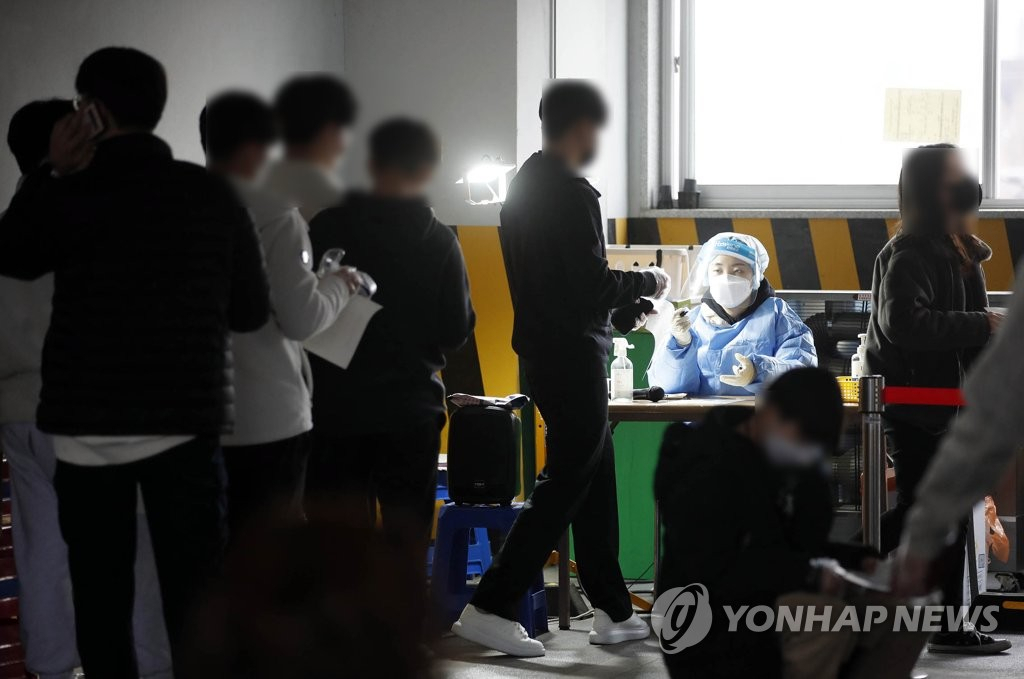 28일 오후 광주 북구 선별진료소에서 신속 항원 검사를 받은 시민들이 자가 검사 키트의 이상 유무를 확인받고 있다. [연합]