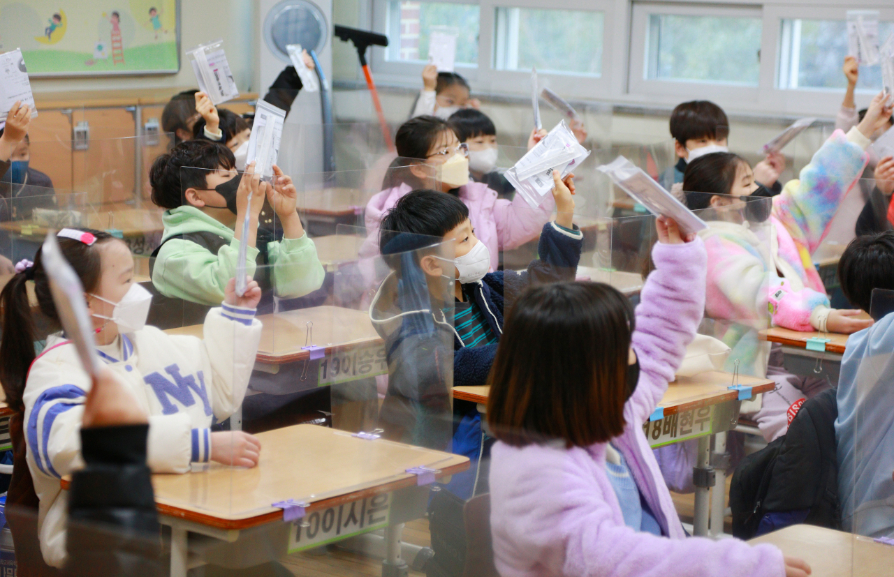 초등학교 3학년 교실에서 1교시 방역 수업에 들어가며 담임교사가 학생들에게 코로나 자가 진단키트를 나눠준 뒤 확인하고 있다. 연합뉴스