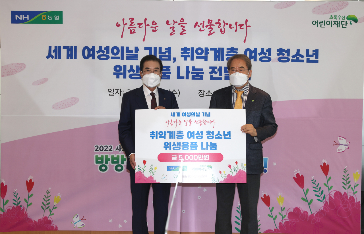 이성희 농협중앙회장(왼쪽)이 2일 서울 중구 농협중앙회 본관에서 개최된 '세계 여성의날 기념, 취약계층 여성 청소년을 위한 위생용품 지원 행사'에서 이제훈 초록우산 어린이재단 회장에게 기금을 전달한 뒤 기념 촬영하고 있다. [농협중앙회 제공]