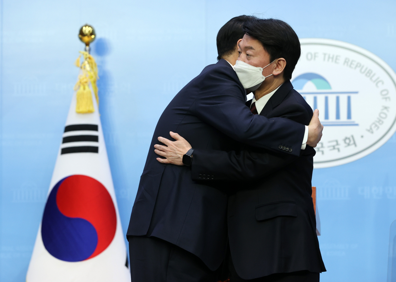 윤석열 국민의힘 대선 후보와 안철수 국민의당 대선 후보가 3일 오전 국회 소통관에서 단일화 기자회견을 마치고 포옹하고 있다. [연합]