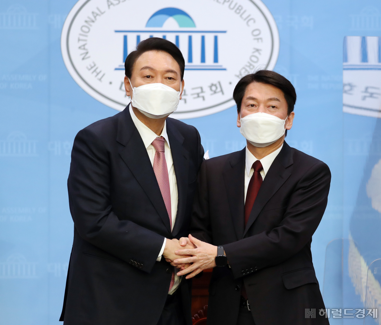 야권 단일화에 전격 합의한 윤석열 국민의힘 대선후보와 안철수 국민의당 대선후보가 3일 오전 서울 여의도 국회 소통관에서 공동 기자회견을 마친 뒤 함게 손을 잡고 있다. [이상섭 기자]