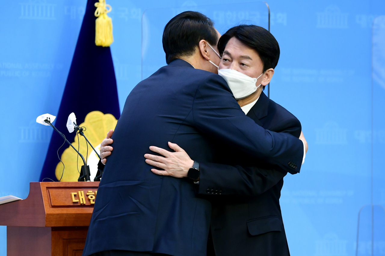 윤석열 국민의힘 대선 후보와 안철수 국민의당 대선 후보가 3일 오전 국회 소통관에서 단일화 기자회견을 마치고 포옹하고 있다. [연합]
