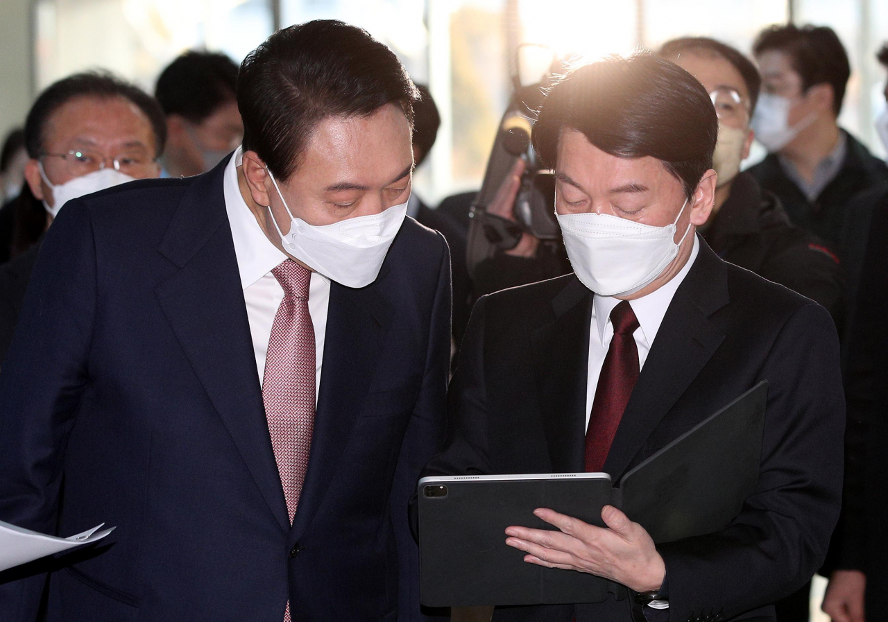 윤석열(왼쪽) 국민의힘 대선후보와 안철수 국민의당 대선후보가 3일 오전 서울 여의도 국회 소통관에서 단일화 기자회견을 하기 전 최종적으로 합의문을 살펴보고 있다. [연합]