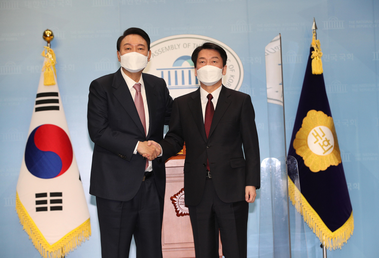 윤석열 국민의힘 대선후보와 안철수 국민의당 대선후보가 3일 오전 국회 소통관에서 단일화 기자회견을 마친 뒤 악수하고 있다. [연합]