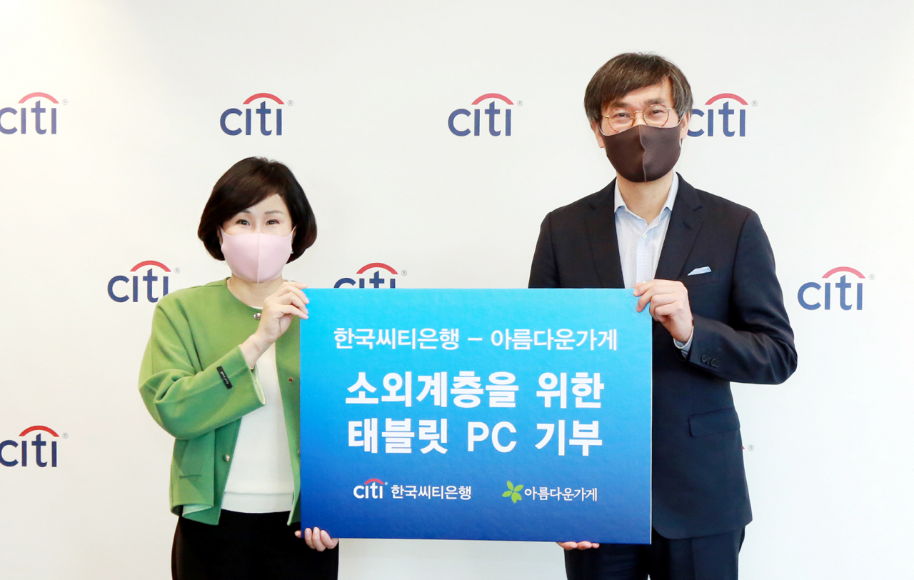 한국씨티은행은 아름다운가게와 함께 3일 오전 서울 종로구 새문안로 소재 한국씨티은행 본점에서 비영리단체 및 소외계층 지원을 위한 전달식을 가졌다. 이날 전달식에서 유명순 한국씨티은행장(사진 왼쪽)이 윤여영 아름다운가게 상임이사에게 태블릿 PC를 전달하고 있다.[한국씨티은행 제공]