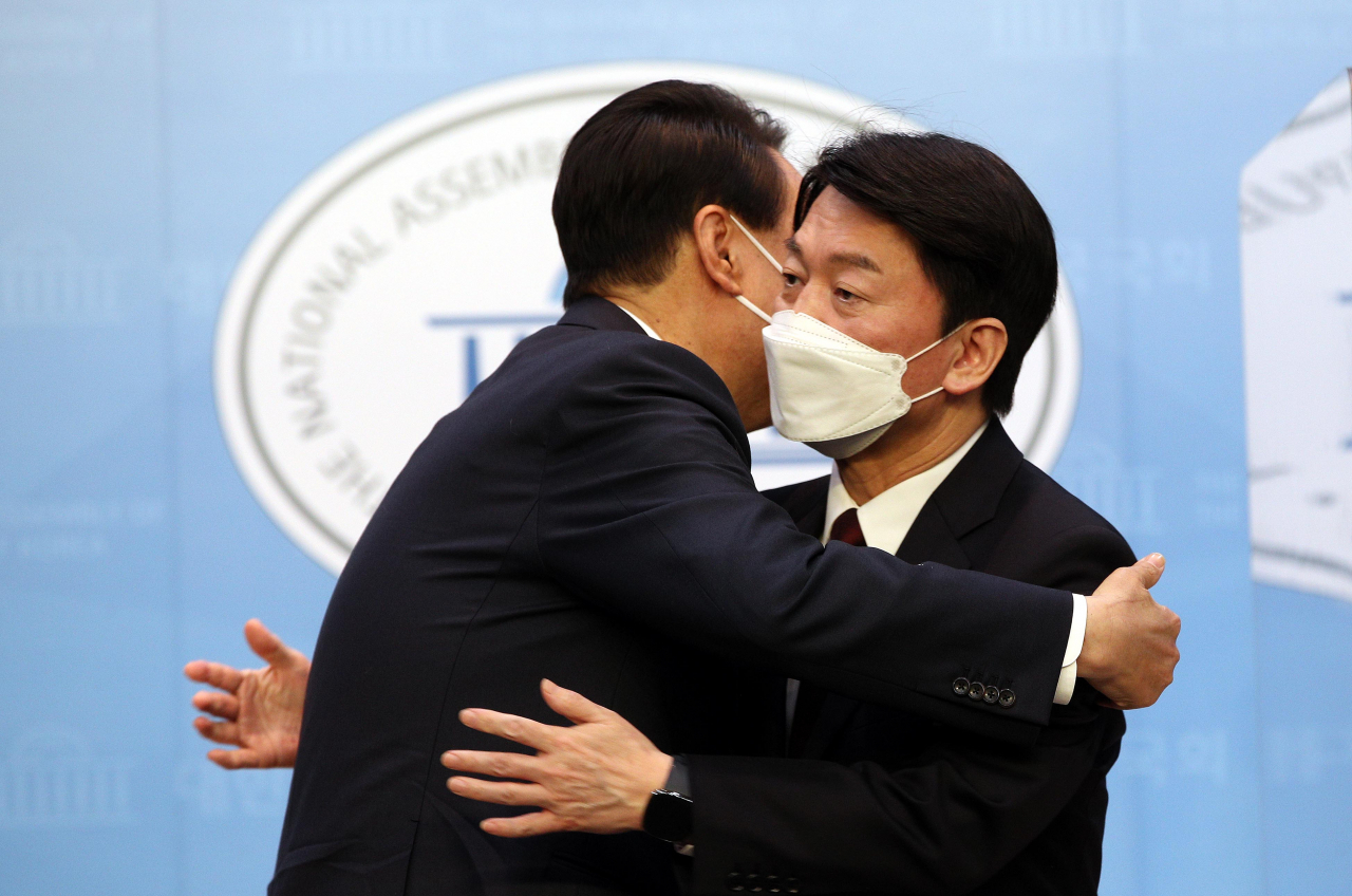 윤석열 국민의힘 대선후보와 안철수 국민의당 대선후보가 3일 오전 국회 소통관에서 단일화 기자회견을 마치며 포옹하고 있다. [연합]