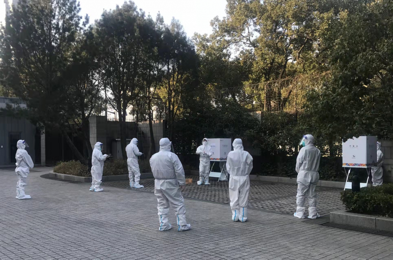 상하이 격리 호텔에 머무르고 있는 국민 9명이 지난달 26일 오전 주상하이 총영사관 마당에 마련된 야외 투표소에서 재외국민 투표를 했다. 사진은 방호복을 입고 투표에 참여하는 국민들 모습. [주상하이 총영사관·연합]