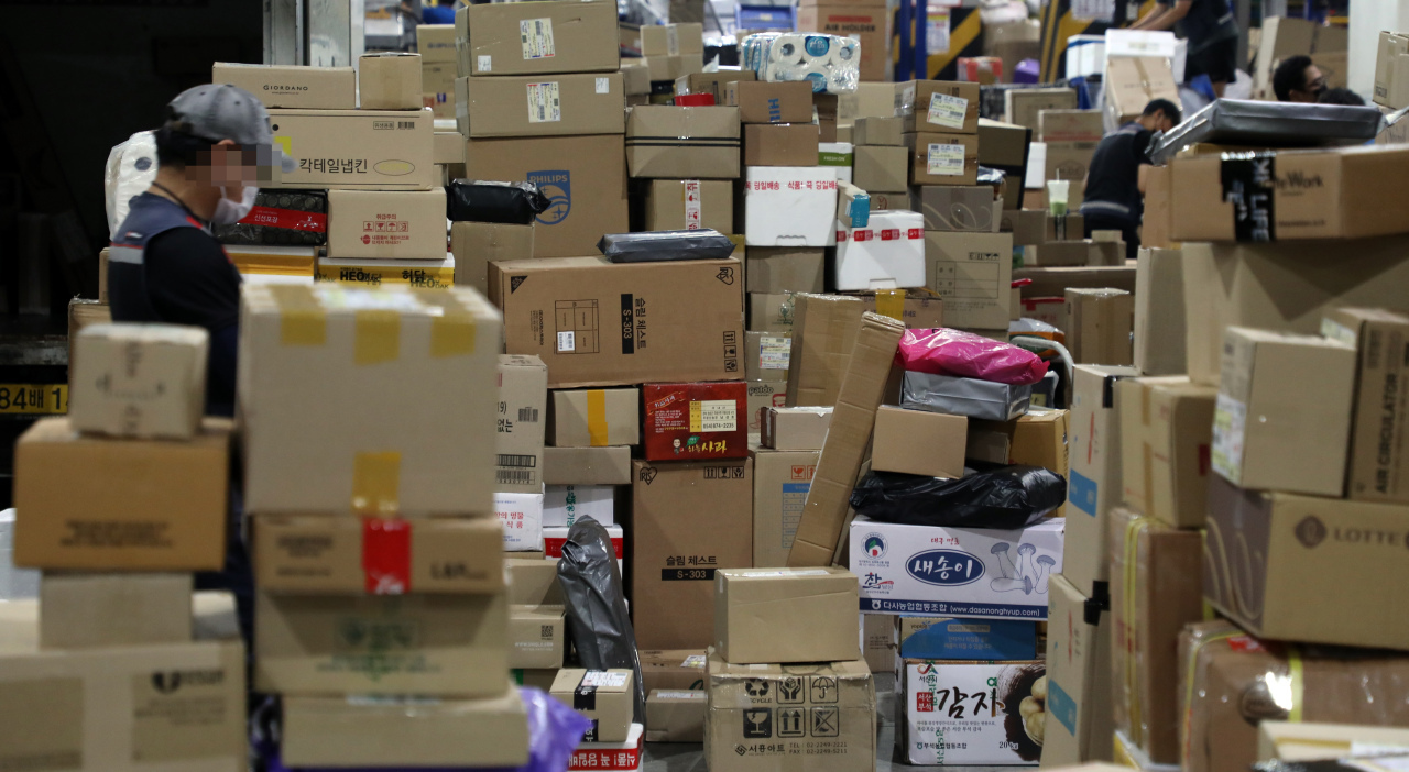 A delivery worker sorts parcels at a logistics center in this file photo from 2021. Yonhap