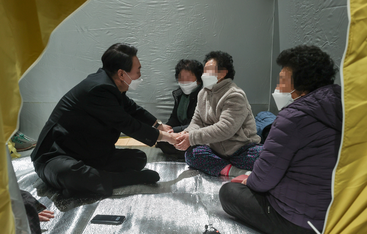 국민의힘 윤석열 대선 후보가 4일 밤 경북 울진군 울진국민체육센터에 마련된 이재민 보호소를 방문해 주민들을 위로하고 있다. [연합]