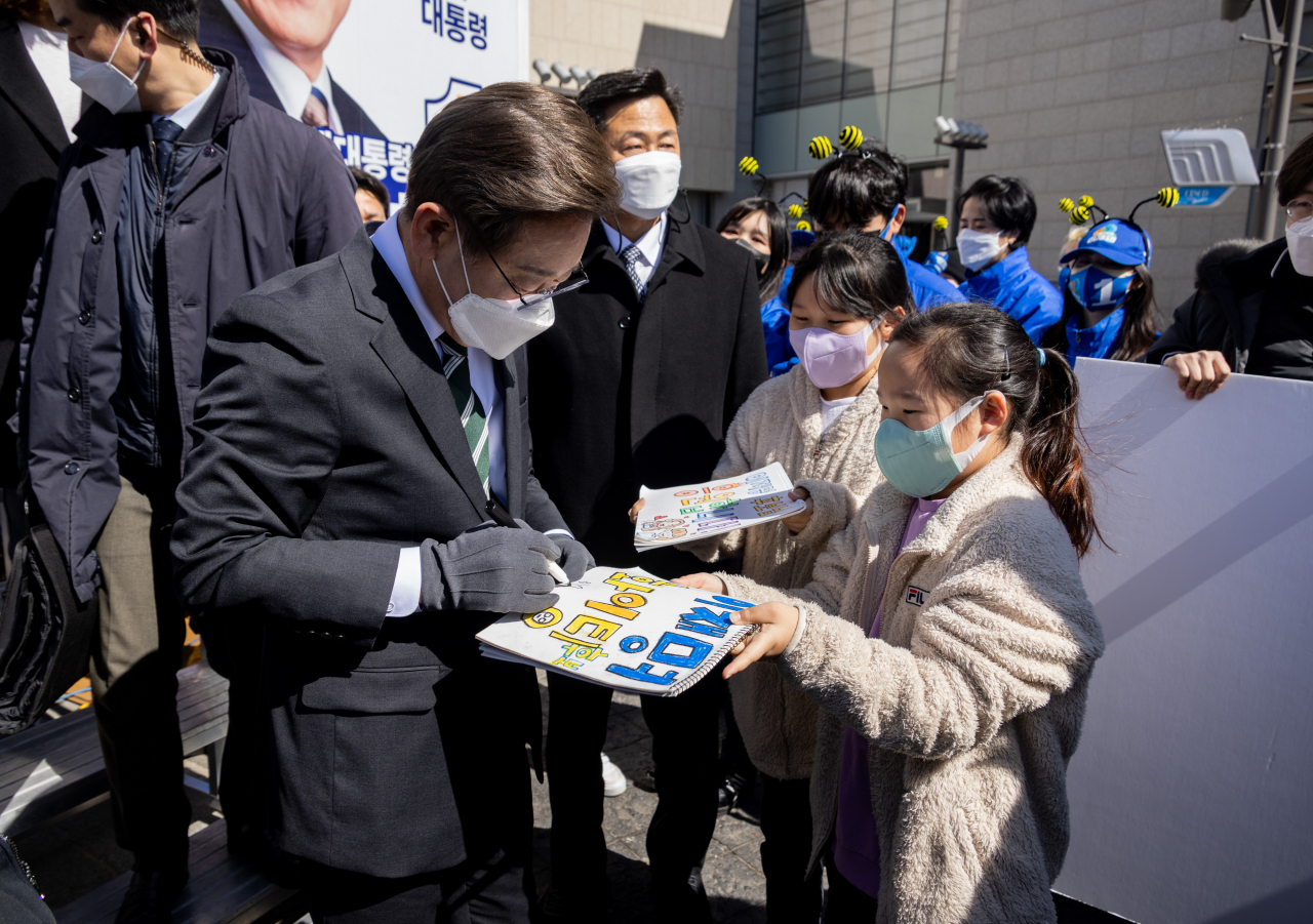 이재명 더불어민주당 대선후보가 5일 경기도 하남시 스타필드 정문 앞에서 열린 '동부권 자유경제특구와 신도시, 교통허브로 비상하는 광주·하남!' 광주·하남 유세에서 어린이에게 사인해 주고 있다. [연합]