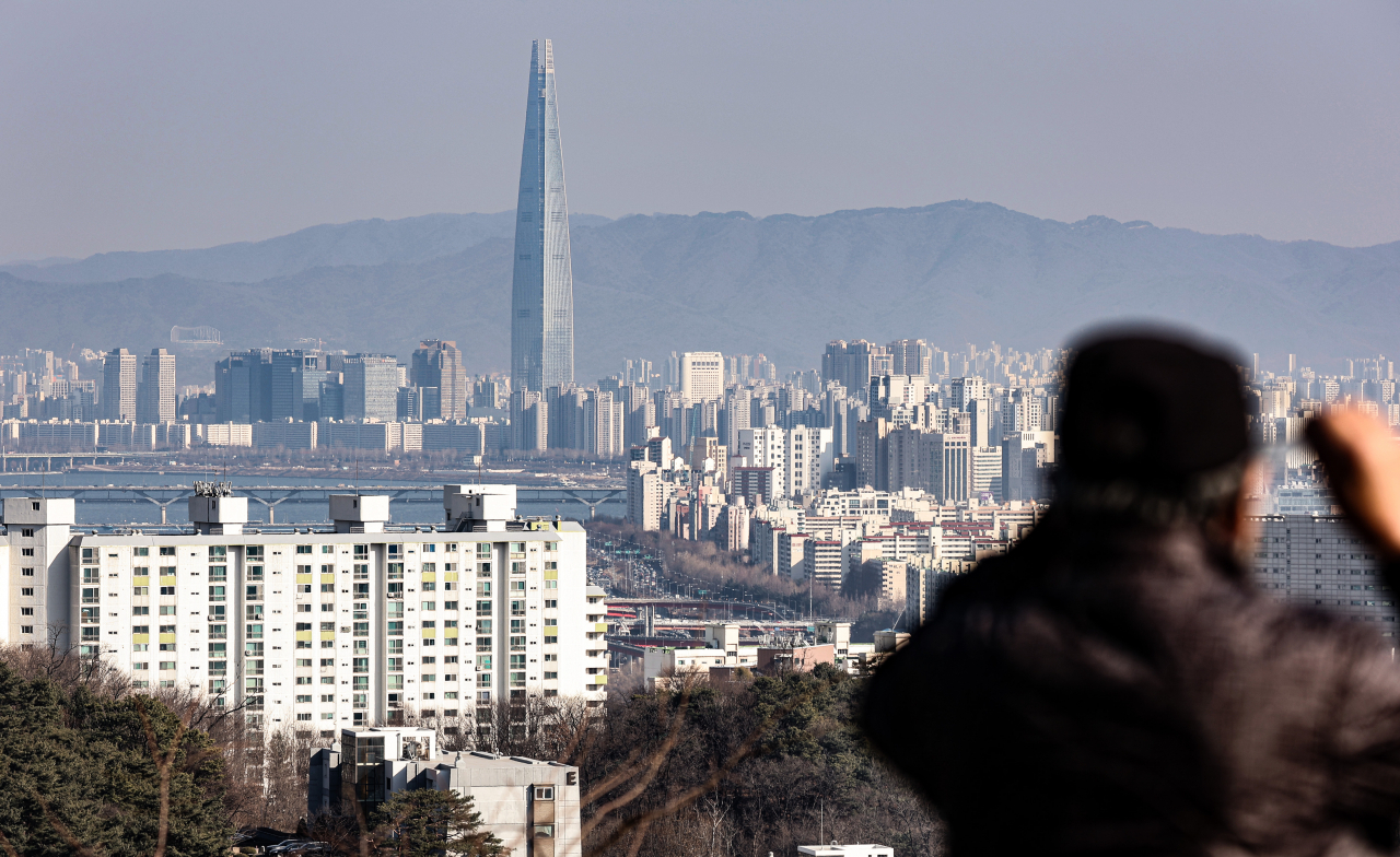 서울 남산 전망대를 찾은 시민이 강남구와 송파구 한강 근처 아파트를 바라보고 있다. [연합]