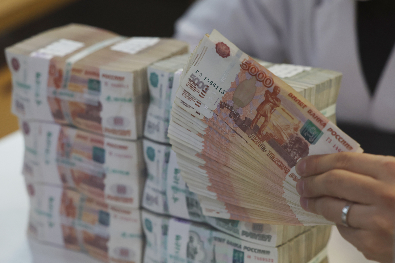 A Hana Bank employee hands Russian rubles at the lender’s headquarters in central Seoul on Feb. 28. (Yonhap)