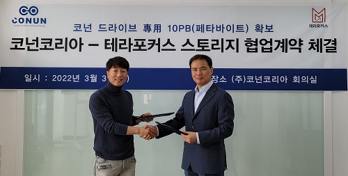 표세진 코넌코리아 회장과 송완호 테라포커스 회장이 싸이월드 서비스 오픈에 대비해 10페타바이트(PB) 용량의 스토리지 시스템 구축을 위한 협업계약을 체결했다. [코넌코리아 제공]