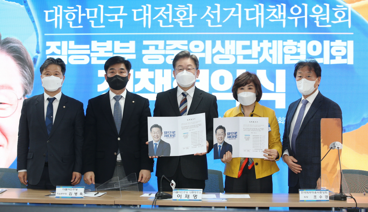 이재명 더불어민주당 대선 후보가 지난달 10일 오후 서울 여의도 중앙당사에서 열린 직능본부 공중위생단체협의회 정책협약식에서 조수경 한국피부미용사중앙회장 등과 협약서를 들고 기념촬영을 하고 있다. [이상섭 기자]