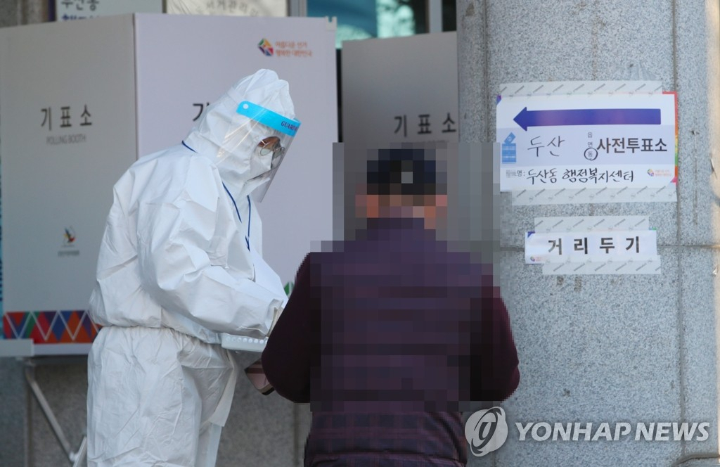 지난 5일 대구 수성구 두산동행정복지센터 사전투표소에서 코로나19 확진자 혹은 격리자가 투표 용지를 받고 있다. [연합]