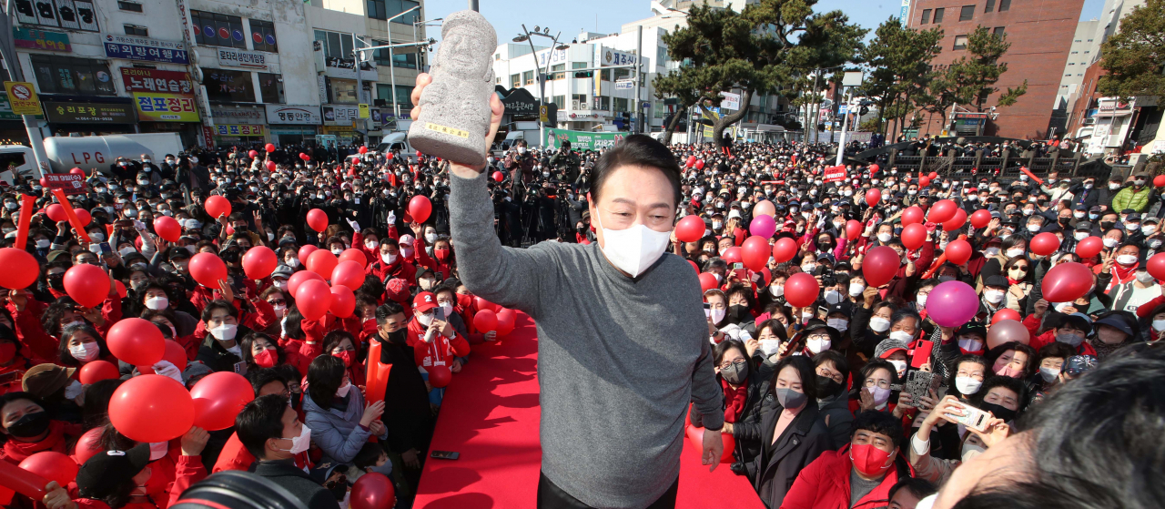 윤석열 국민의힘 대선 후보가 8일 제주시 동문시장 일대에서 열린 ‘제주와 함께 승리합니다’ 제주도 거점유세에서 지지자들에게 받은 돌하르방을 들어보이고 있다. [연합]