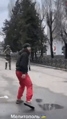 우크라이나 남부 소도시 멜리토폴의 시민이 러시아군에 맞서 맨몸으로 저항하고 있는 모습. 남성 뒤에는 멜리토폴의 시민이 우크라이나 국기를 흔들며 시위하고 있다. [Round World 유튜브 캡처]
