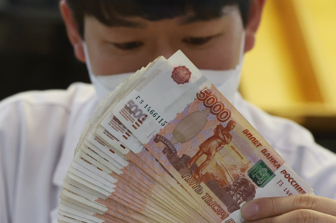 A Hana Bank official handles Russian ruble banknotes at the bank’s headquarters in central Seoul on Feb. 28. (Yonhap)