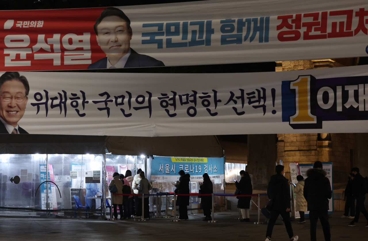제20대 대통령선거를 하루 앞둔 8일 오후 독립문 광장에 마련된 코로나19 선별검사소에 시민들이 PCR 검사를 받기 위해 줄을 서서 기다리고 있다. 서울시 등 각 지방자치단체에 따르면 이날 0시부터 오후 9시까지 전국 17개 시도에서 코로나19 확진 판정을 받은 사람은 32만6834명으로 집계됐다. [연합]