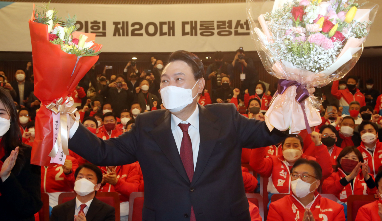 윤석열 대통령 당선인이 10일 새벽 서울 여의도 국회도서관에 마련된 '국민의힘 제 20대 대통령선거 개표상황실'에서 꽃다발을 들고 포즈를 취하고 있다. [이상섭 기자]