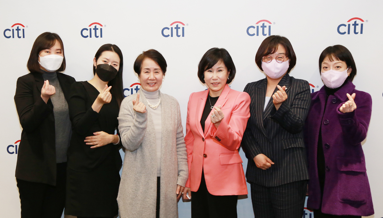 한국씨티은행은 지난 8일 ‘2022 세계 여성의 날’을 기념해 ‘우아한 승부사’를 주제로 윤여순 박사와 유명순 한국씨티은행장과의 대담 행사를 비대면으로 개최했다. 윤여순 박사(좌측 세 번째부터), 유명순 한국씨티은행장, 이주현 한국씨티은행 여성위원회 위원장이 한국씨티은행 직원들과 함께 기념사진을 촬영하고 있다.[한국씨티은행 제공]