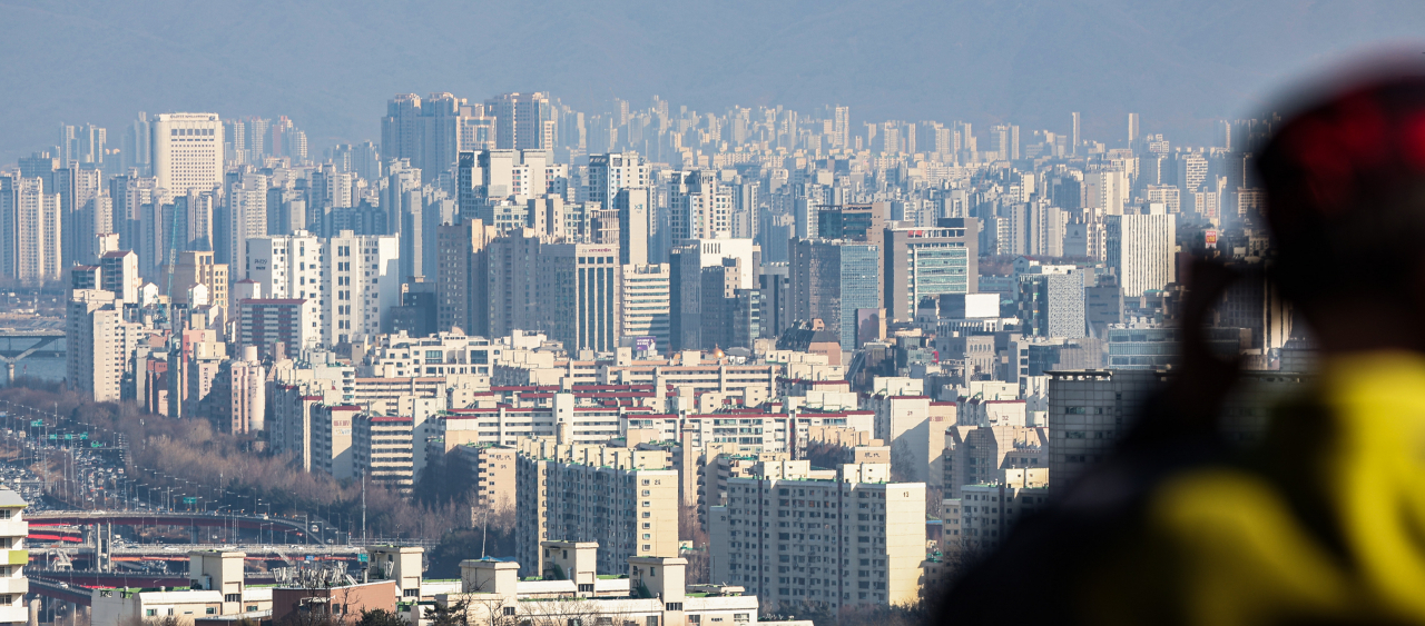 서울 남산 전망대를 찾은 시민이 강남구와 송파구 한강 근처 아파트를 바라보고 있다. [연합]