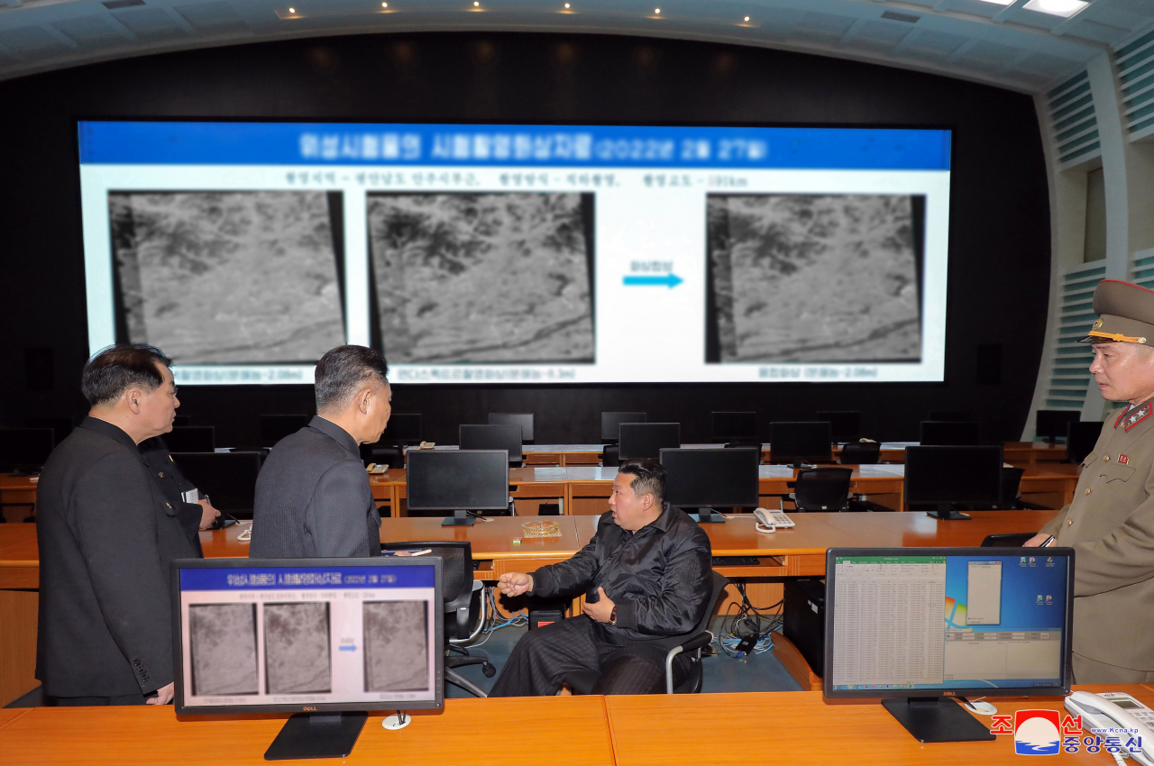 North Korea leader Kim Jong-un (C) speaks to officials during a visit to the National Aerospace Development Administration in this photo released by the North's official Korean Central News Agency on Thursday. (KNCA)