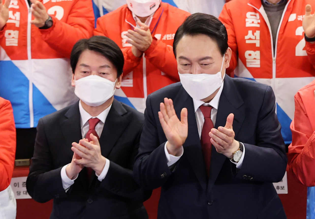 윤석열 제20대 대통령 당선인이 10일 새벽 서울 여의도 국회도서관에 마련된 '국민의힘 제 20대 대통령선거 개표상황실'을 찾아 박수를 치고 있다. 왼쪽은 안철수 국민의당 대표. [연합]