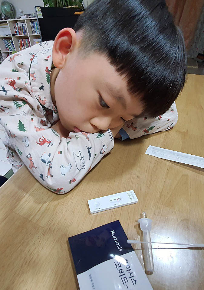 지난 7일 오전 광주 북구 운암동의 한 가정에서 초등학생이 등교 전 자기진단 키트로 코로나19 신속항원 검사를 하고 결과를 초조하게 기다리고 있다. [연합]