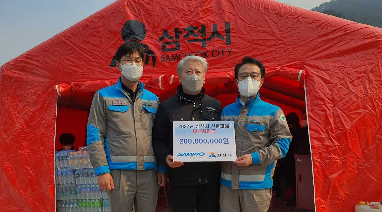 이종석 삼표시멘트 대표이사(오른쪽)가 지난 8일 김양호 삼척시장(가운데)에게 산불 피해 복구를 위한 성금을 전달했다.[삼표시멘트 제공]