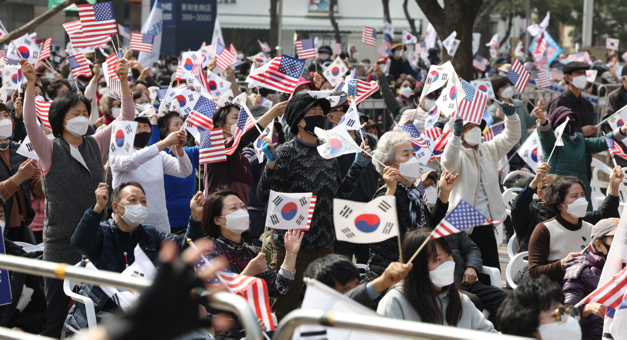 코로나19 신규 확진이 팬데믹 이후 최다를 기록한 12일 오후 서울 중구 감리교 회관 앞에서 전광훈 사랑제일교회 담임 목사가 대표로 있는 국민혁명당 주최로 열린 1천만 자유 통일 기도회에서 참석자들이 태극기와 성조기를 흔들며 찬송을 부르고 있다. [연합]