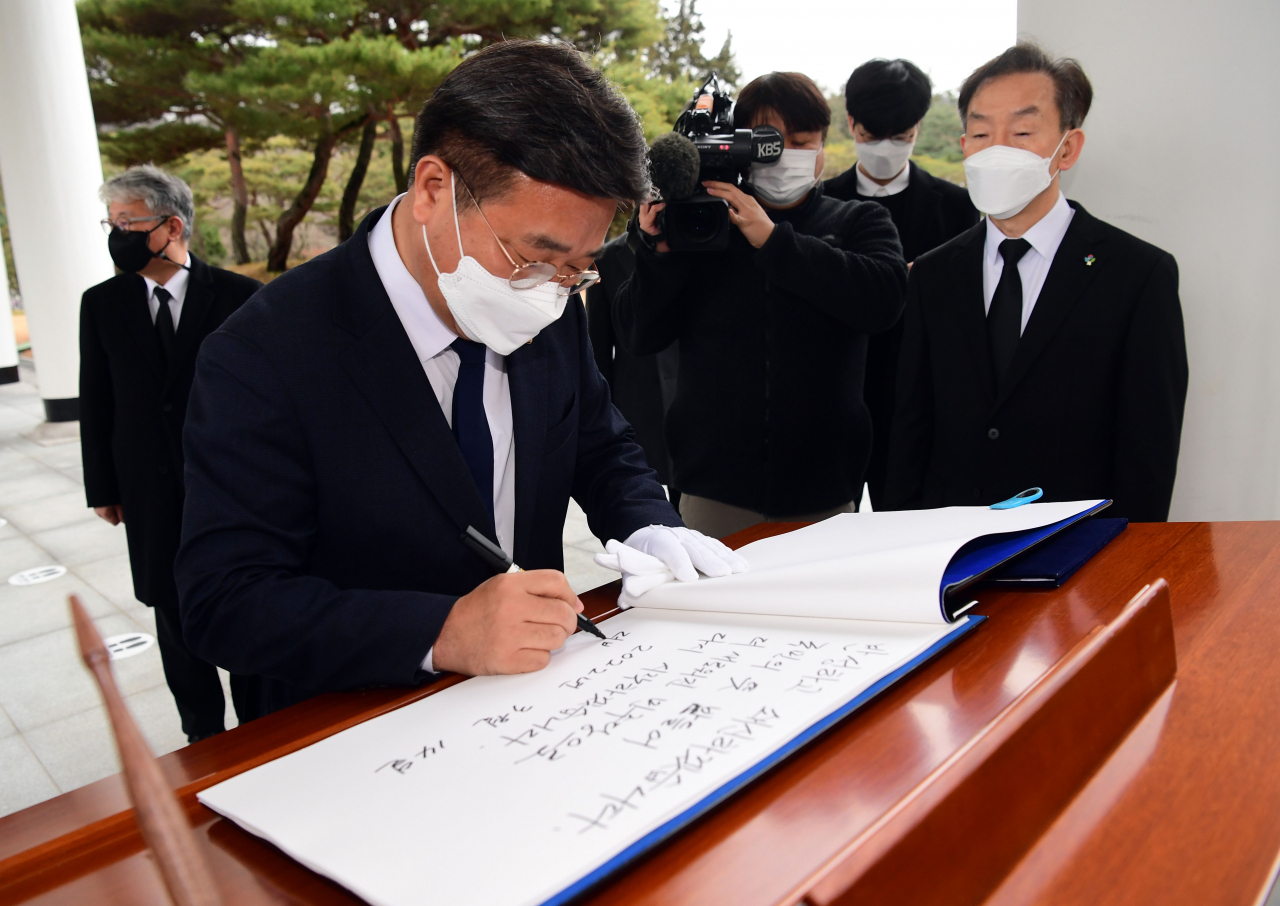 윤호중 더불어민주당 비상대책위원장이 14일 오전 서울 동작구 국립서울현충원을 참배한 뒤 방명록을 작성하고 있다. [연합]