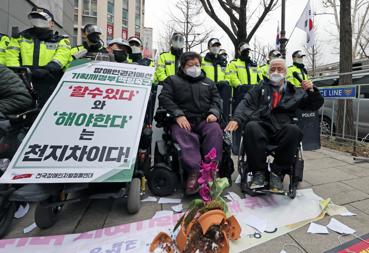 14일 오전 박경석 전국장애인차별철폐연대 상임공동대표가 윤석열 대통령 당선인 집무실 인근에서 열린 인수위 장애인 권리예산 반영 촉구 기자회견에서 면담과 자료 전달이 무산되자 축하 난을 던지고 있다. [연합]