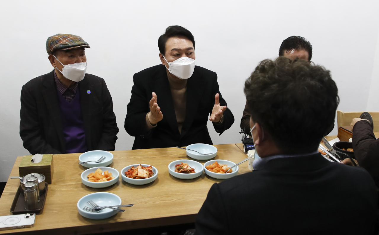 윤석열 대통령 당선인이 14일 당선 이후 첫 외부 공식일정으로 서울 남대문 시장을 찾아 상인회 회장단과 간담회를 마친 뒤 식당에서 이야기를 나누고 있다. [연합]