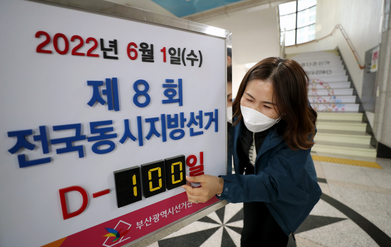 6·1 지방선거가 100일 앞으로 다가온 2월 21일 부산 연제구 부산시선관위에서 직원이 전광판 숫자를 D-100으로 바꾸고 있다. [연합]