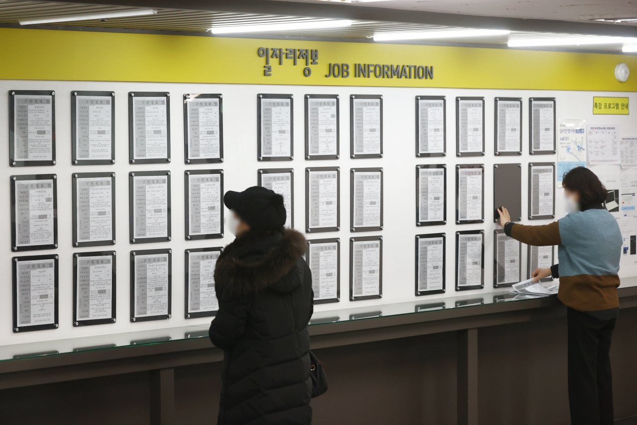 Citizens look at employment information put up on a bulletin board at a state-run job center in Seoul, in this file photo from Feb. 16, 2022. (Yonhap)