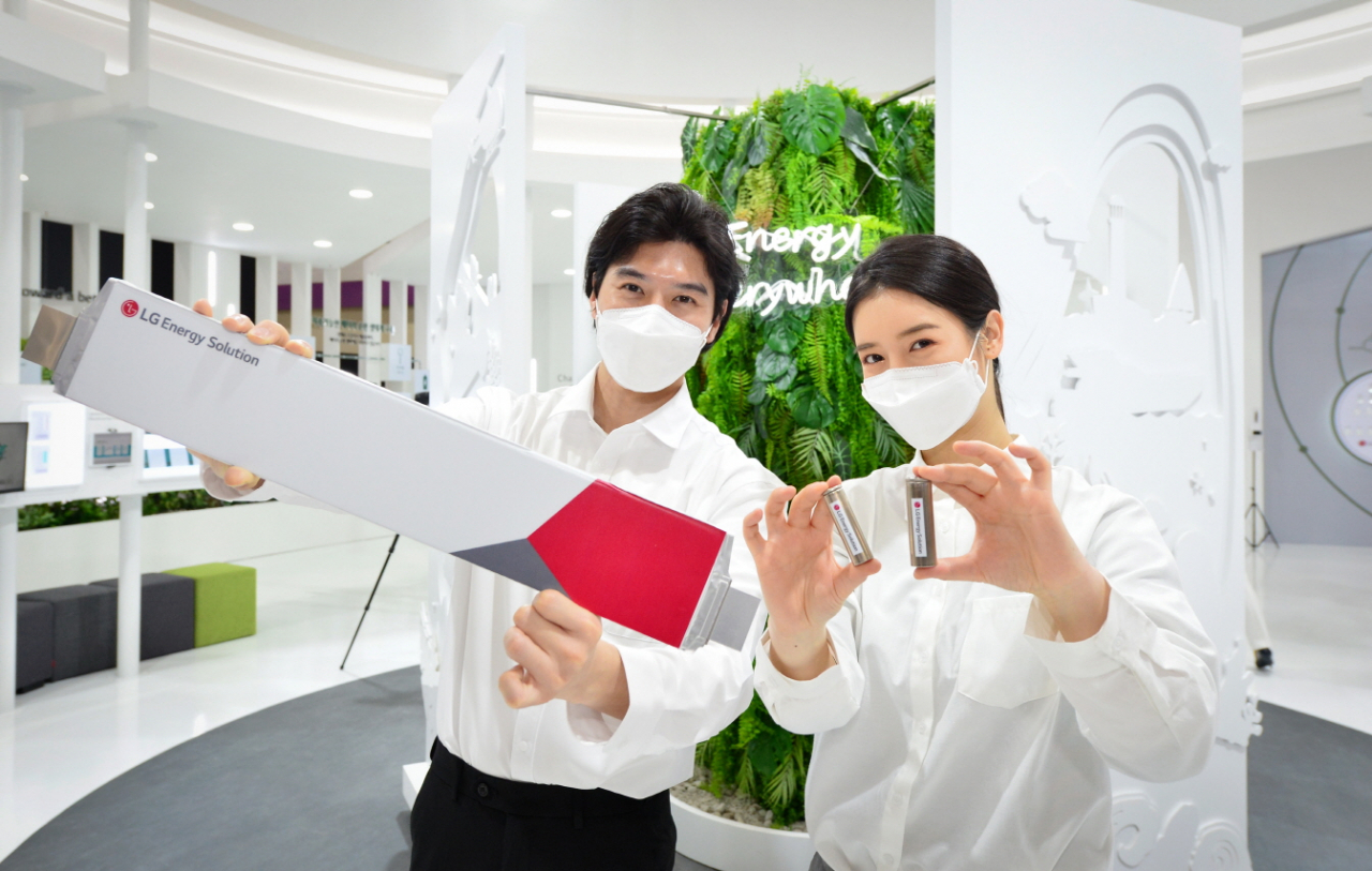 LG에너지솔루션 전시회 관계자들이 17일 서울 코엑스에서 개막한 ‘인터배터리 2022’에서 파우치형 배터리인 롱셀 배터리(왼쪽)와 원통형 배터리(오른쪽)을 들고 포즈를 취하고 있다.