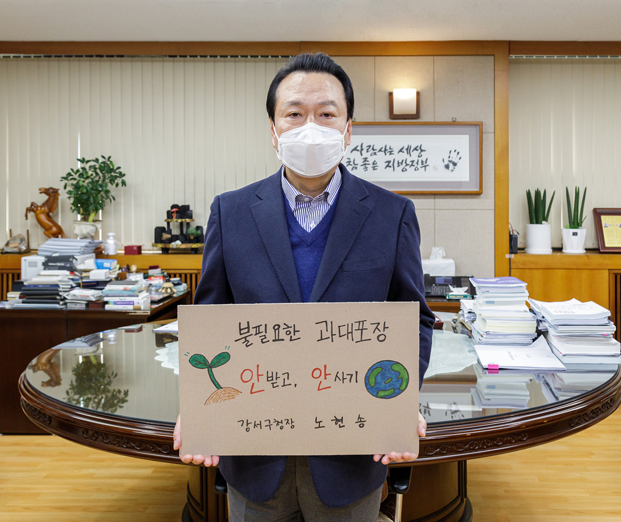 노현송 서울 강서구청장이 17일 구청 집무실에서 ‘과대포장 안 받고 안 사기’ 챌린지에 동참하고 있다. 이번 챌린지는 생활 속 과대포장과 일회용품 사용을 줄여 폐기물 감량을 실천하고 더 나아가 탄소중립 순환경제를 실현하자는 취지로 시작된 캠페인이다. [강서구 제공]