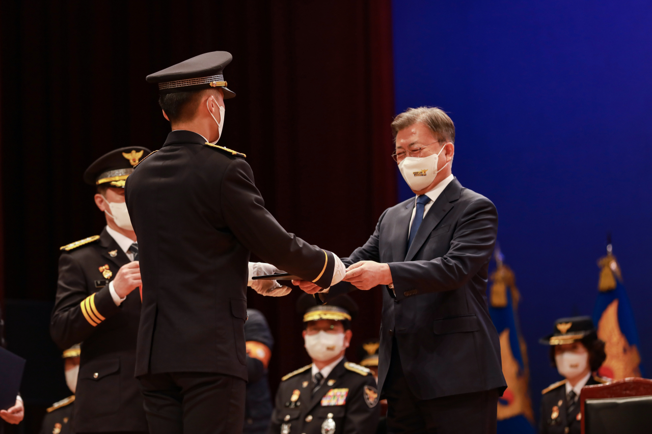 문재인 대통령이 17일 충남 아산 경찰대학 대강당에서 열린 신임 경위·경감 임용식에서 상장과 임명장을 수여하고 있다. [경찰대학 제공]