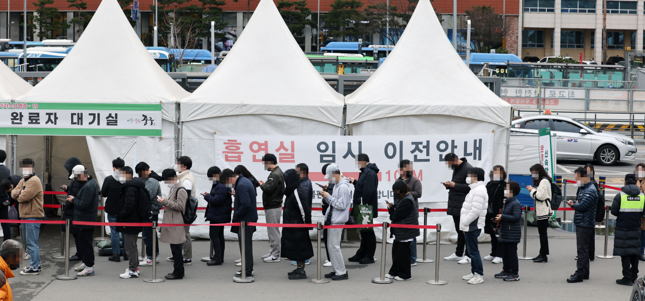 18일 서울역 광장에 마련된 코로나19 임시 선별검사소에서 검사를 받으려는 시민들이 줄을 서고 있다. [연합]