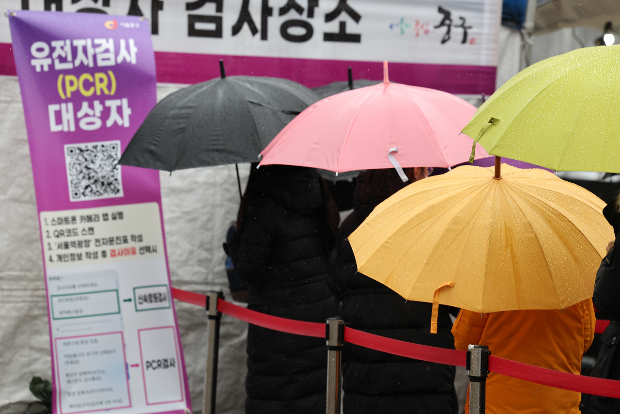 지난 19일 비가 내리는 가운데 서울 중구 서울역 임시 선별검사소에서 우산을 쓴 시민들이 검사를 기다리고 있다. [연합]