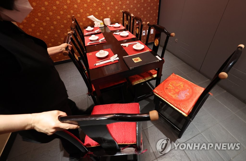 20일 서울 양천구의 한 중식당에서 직원이 21일부터 시행되는 사회적 거리두기 조정 관련 8명 단체손님을 받기 위해 단체석을 조정하고 있다. [연합]
