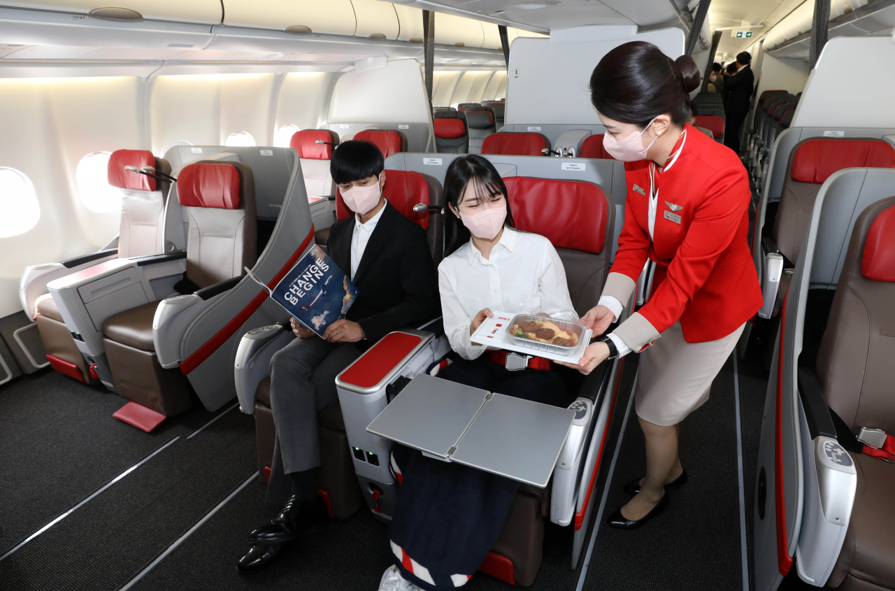 티웨이항공이 최대 1만km까지 운항 가능한 A330-300기를 도입해 17일 김포국제공항에서 공개했다. 347석 규모의 A330-300은 중장거리 노선 운항에 적합한 기종이다. 사진은 비즈니스석에 제공되는 서비스를 시연하는 승무원. [연합]