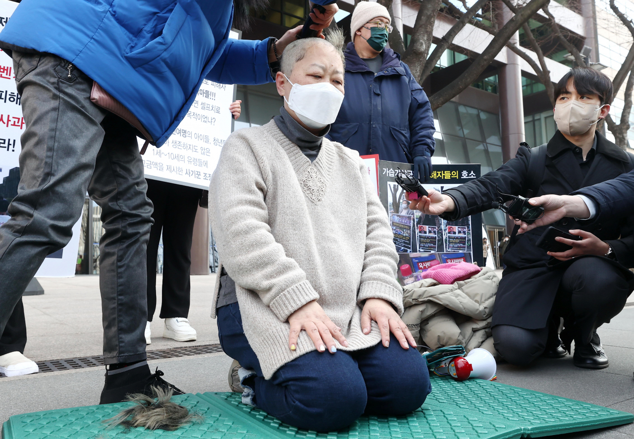 22일 오전 서울 종로구 교보빌딩 앞에서 박수진 가습기살균제 피해정보 공유모임 대표가 가습기살균제피해구제를위한조정위원회의 조정안 전면 수정을 요구하며 삭발하고 있다. [연합]