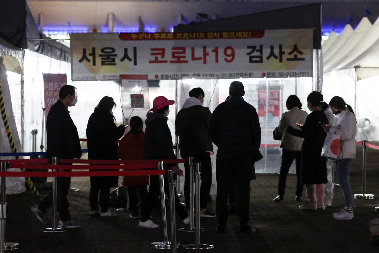 22일 오후 서울 마포구 월드컵공원 평화광장 임시선별검사소에서 피검자들이 줄을 서 있다. 이날 오후 6시까지 선별진료소 PCR 검사나 병·의원 신속항원검사를 통해 전국에서 33만7027명의 확진자가 나오면서 누적 확진자 수가 1000만명을 돌파했다. 연합뉴스
