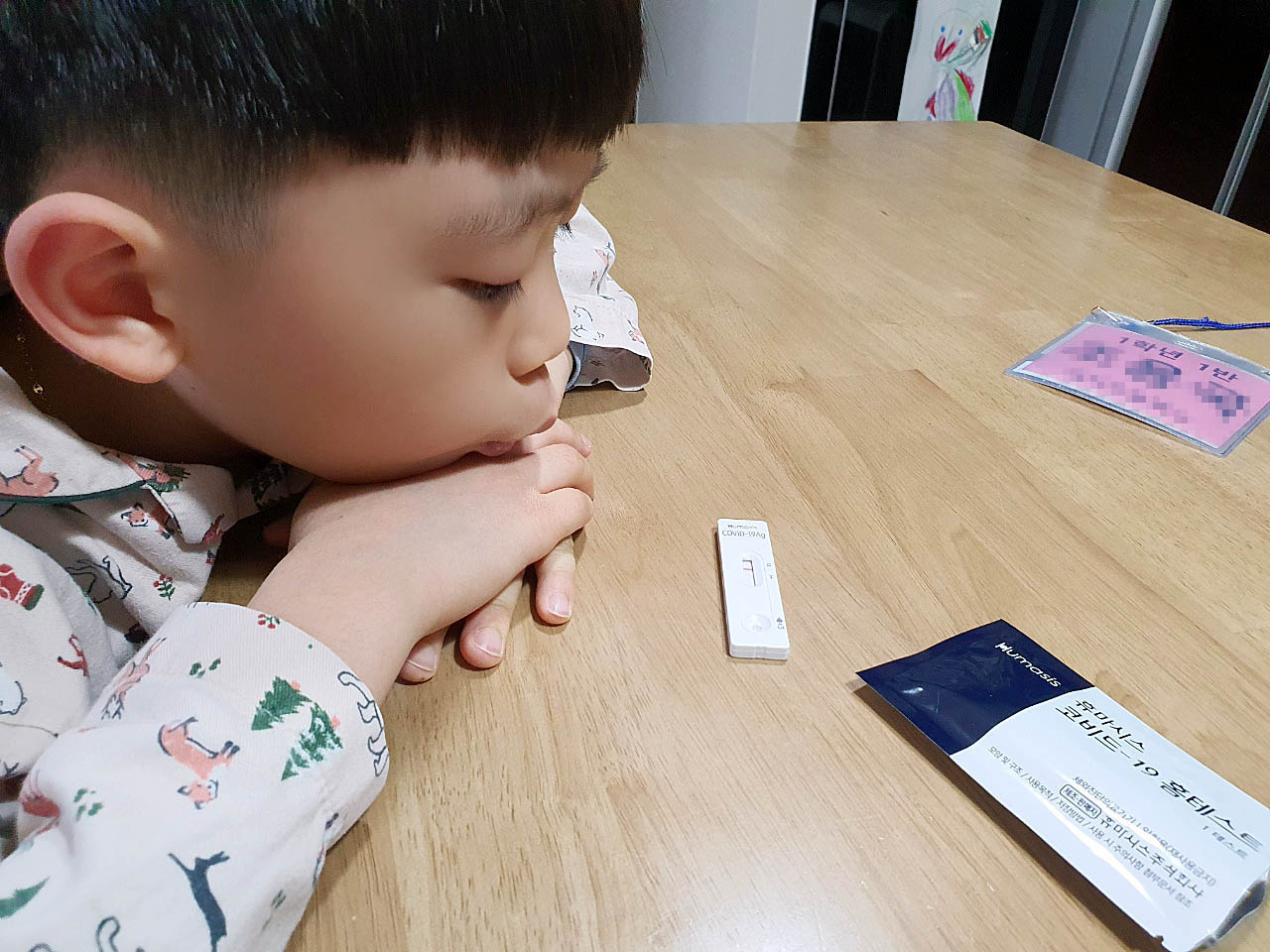 지난 7일 오전 광주 북구 운암동의 한 가정에서 초등학생이 등교 전 자가검사키트로 코로나19 신속항원검사를 한 뒤 결과를 초조하게 기다리고 있다. [연합]
