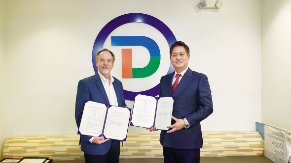 엔피는 미국 디버시파이드와 글로벌 비즈니스 업무협약을 체결했다고 23일 밝혔다. 사진은 케빈 콜린스 디버시파이드 글로벌 대표(왼쪽)와 송방호 엔피 대표(오른쪽)가 기념 사진을 촬영하는 모습. [엔피 제공]